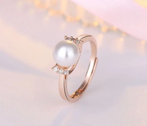 Detail of rose gold pearl ring with side diamonds and adjustable open band