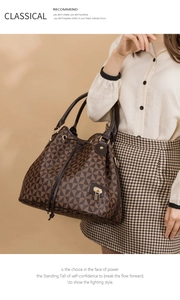 Detail of vintage bucket bag featuring geometric patterns, leather handle and gold lock