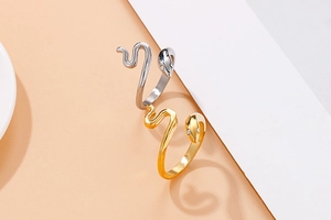 Detailweergave van de slangenringen in goud en zilver met zirkoon ogen en textuur