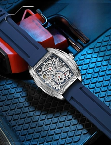 Detail of tonneau-shaped silver steel case with skeleton mechanical movement and blue strap