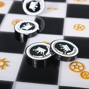 Macro shot of crown patterned resin earring charms on a classic checkered background