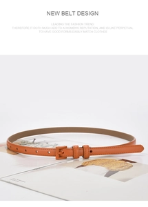 Detail of slim orange leather belt with matching rectangular buckle on a fashion magazine
