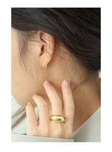 Polished gold earrings and matching chunky ring showcased on model for elegant look
