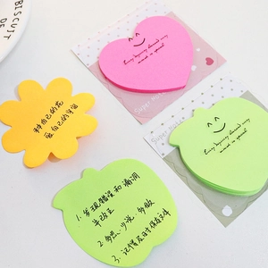 Fluorescent colorful sticky notes in heart flower and apple shapes on a white desk