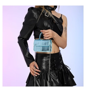 Close-up of light blue crocodile pattern mini bag with silver chain strap and top handle