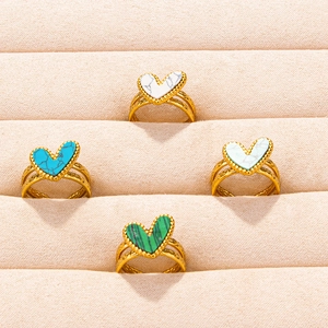 Minimalist gold heart rings set with assorted stone inlays on velvet jewelry tray