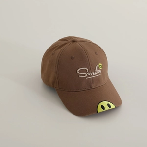 Detail of smile embroidery and white text on brown cotton kids baseball cap