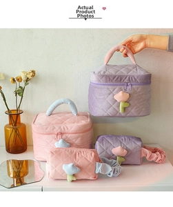 Quilted corduroy cosmetic bag detail with floral patches and spacious portable design