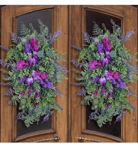 Detailed view of artificial purple tulip and lavender swag on dark wood double doors
