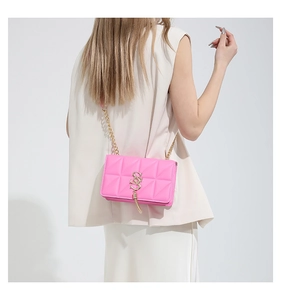 Pink quilted PU leather crossbody bag with gold chain strap shown on model's shoulder