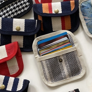 Detail of canvas card holder showing multiple slots for credit cards and metal snap closure