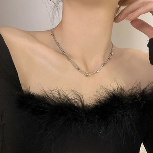 Detailed view of a layered silver stainless steel necklace with small square beads on neck