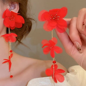 Long red fabric flower tassel earrings with golden chain and faceted beads on model