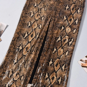 Detailansicht von Schlangenmuster-Stoff mit schimmernden Pailletten und Mittelnaht-Detail
