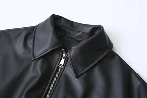 Detail of lapel collar and metal zipper on this vintage black PU leather jacket for women