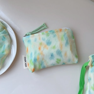 Detail of mint green watercolor tie-dye fabric pouch with a simple wish woven label