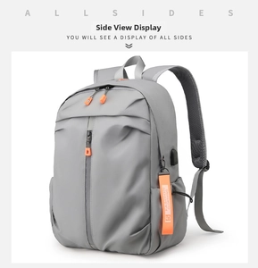 Detail of waterproof grey commuter backpack featuring an external USB port and orange pull tabs