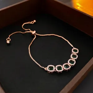 Luxurious adjustable gold bracelet with square green emerald stones and zircon accents
