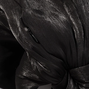 Détail macro du tissu satiné noir brillant avec fermeture éclair invisible et nœud