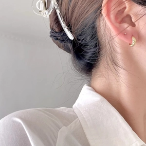Close-up of 925 sterling silver twisted hoop earrings and hair clip on a model