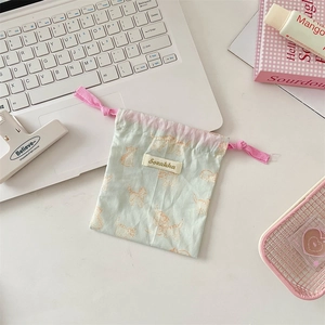 Detail of cute cat print fabric drawstring bag with pink cord and woven label