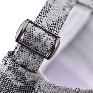 Macro view of thick tweed baseball cap with adjustable metal slider buckle and textured fabric