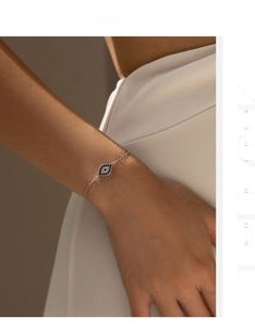 Macro detail of S925 silver evil eye bracelet featuring blue and white crystals on a wrist