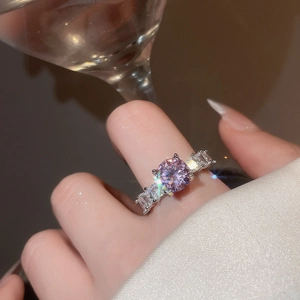 Close-up of elegant silver ring with purple zircon stone and rectangular side accents