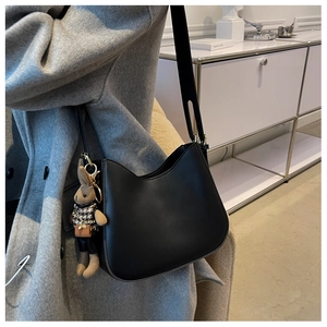 Black leather crescent shoulder bag with adjustable strap and cute bunny charm accessory