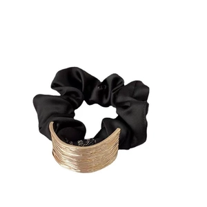 Minimalist black fabric scrunchie featuring a textured wide gold metal geometric ring