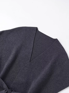 Dettaglio dello scollo a V in maglia grigio scuro con trama a coste sottili