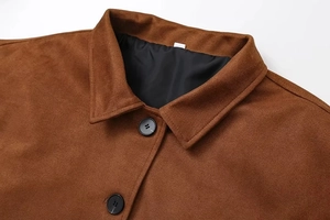 Détail de veste vintage en daim marron montrant le col à revers et les boutons noirs