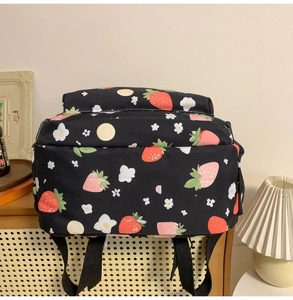 Detailed view of black nylon backpack with cute strawberry and lemon floral prints