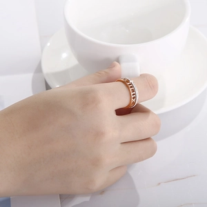 Détail de la bague en or rose avec chiffres romains et cristaux brillants sur la main