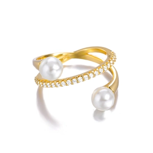Detail of elegant gold-plated criss-cross ring with dual pearls and sparkling zircon stones