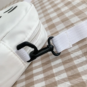 Vue macro détaillée du crochet rotatif en plastique noir et de la sangle en nylon blanc du sac