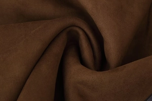 Dettaglio del morbido tessuto in shearling marrone scuro con trama scamosciata