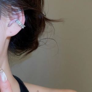 Detailed view of silver leaf-shaped zircon ear cuff on ear without piercing