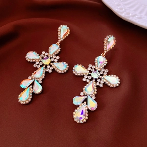 Detailed macro view of vintage golden cross earrings with sparkling colorful rhinestones