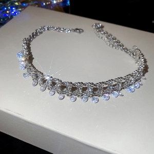 Macro shot of a layered silver tassel necklace with sparkling zircon pendants on a gift box