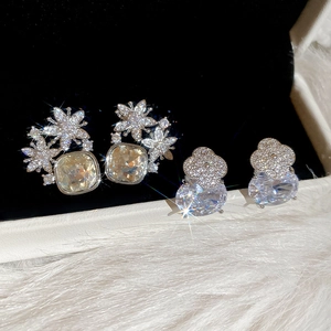 Gros plan de boucles d'oreilles fleurs étincelantes en zircon sur fond de velours noir