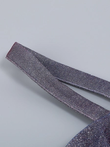 Detail of the glittering blue-purple fabric texture and shoulder strap on a fashion set