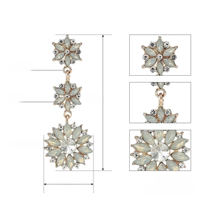 Macro detail of long floral earrings with opal and Austrian crystal on zinc alloy