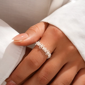 Detailed view of silver hollow lace floral open ring worn on finger with elegant style
