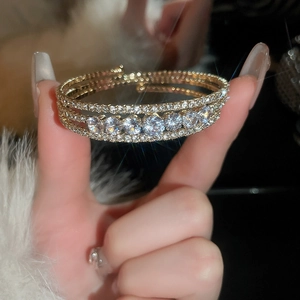 Detailed view of multilayer gold bracelet with sparkling cubic zirconia on a model