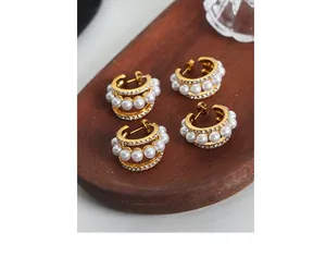 Détails de deux paires de boucles d'oreilles en C dorées avec perles et cristaux