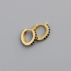 Macro detail of golden sterling silver hoop earrings with micro-pave black cubic zirconia