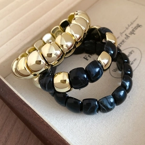Detailed view of 3-piece stretch bracelet set with gold beads and marble resin textures