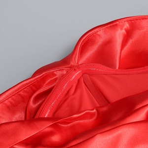 Macro detail of red satin evening gown showing premium fabric texture and fine stitching
