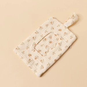 Detail of floral cotton baby wipe pouch with hanging strap and zipper on beige background